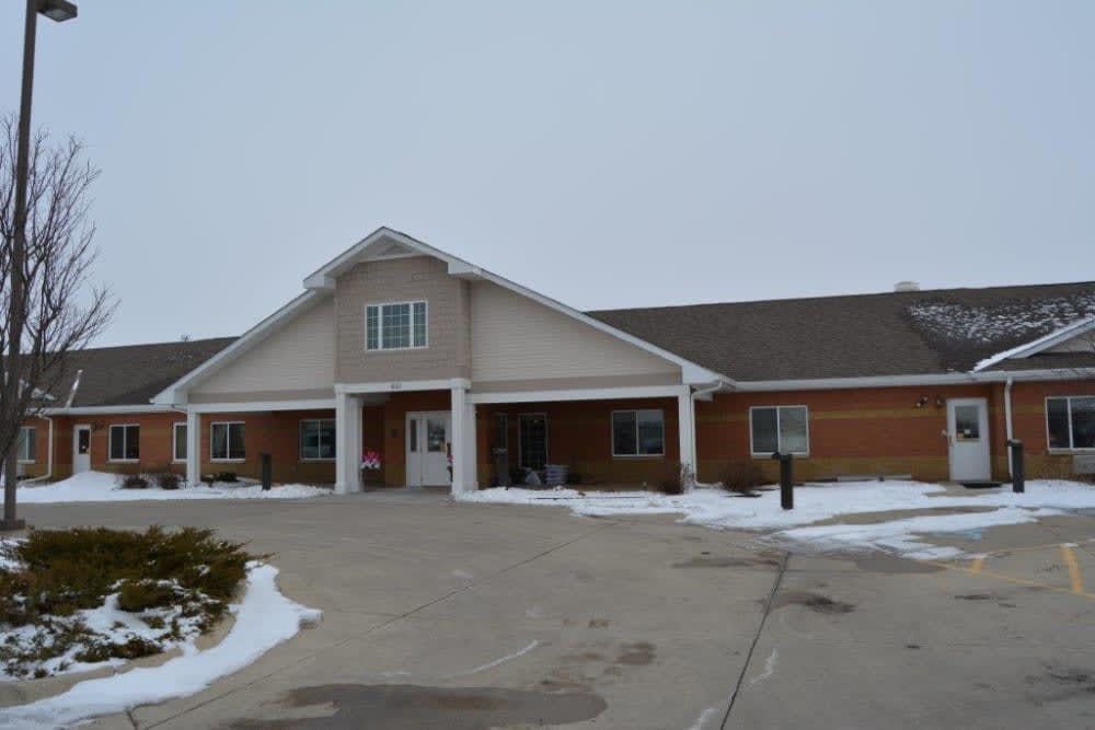 A residential building with a snowy driveway in the winter.