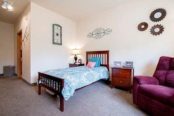 A cozy bedroom with a single bed, nightstand, and decorative elements.