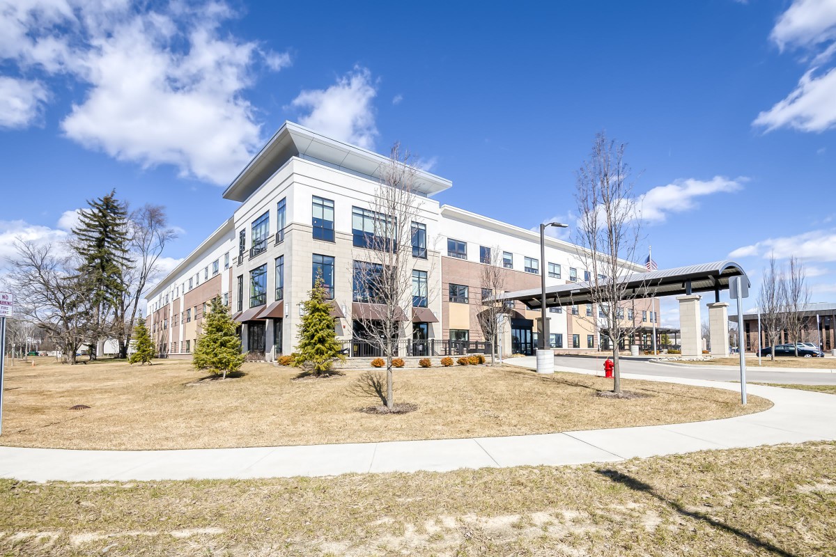 A modern commercial office building on a sunny day with a clear blue sky.