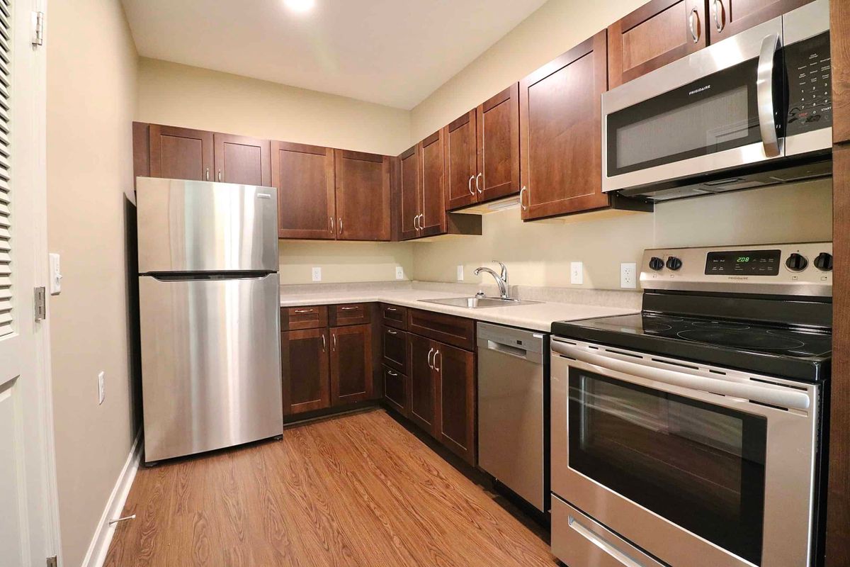 A modern kitchen with stainless steel appliances and wooden cabinets.