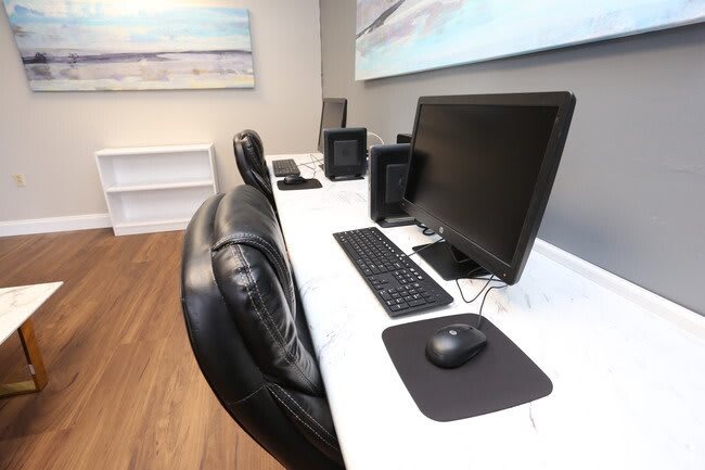 A modern office workspace with computers and comfortable seating.