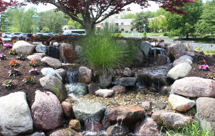 A serene waterfall in a landscaped garden setting.