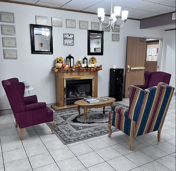 A cozy waiting room with colorful chairs and a decorative fireplace.