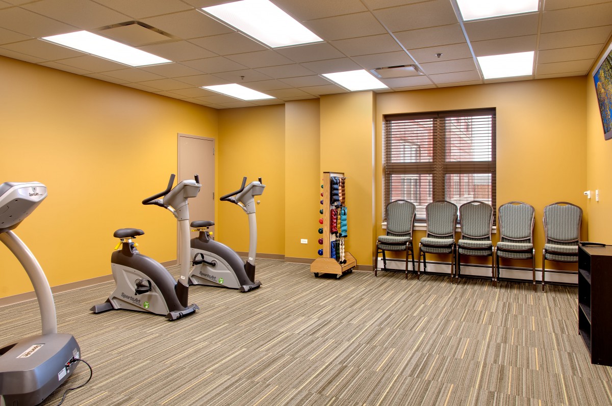 A small gym space with exercise bikes and weights.