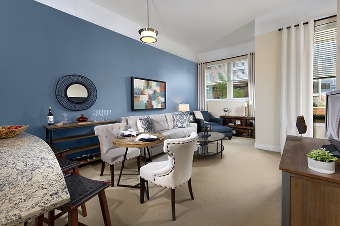 A modern living room with a blue accent wall, stylish furniture, and a cozy ambiance.