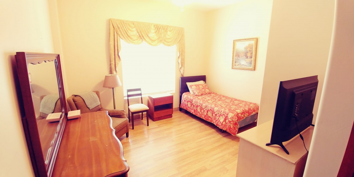 A cozy bedroom with a single bed, furnished with a chair, dresser, and a window adorned with curtains.