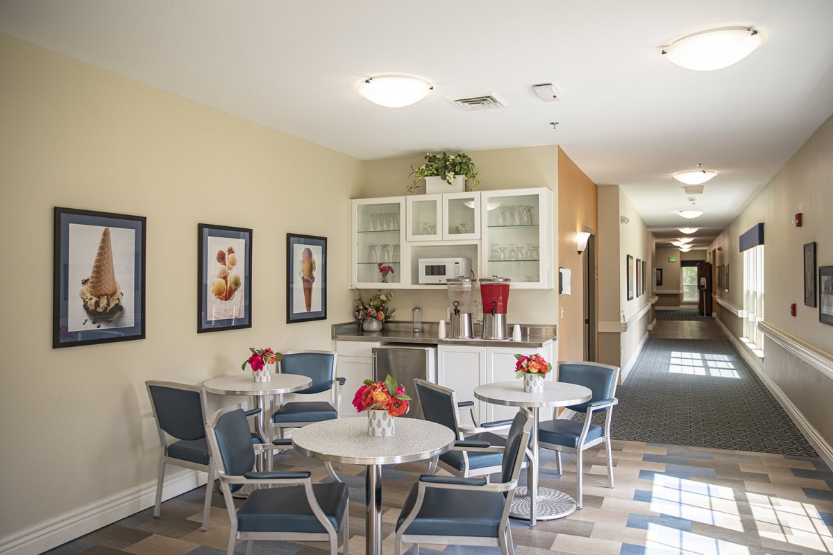 A cozy cafe area with tables and chairs, adorned with decorative flowers.