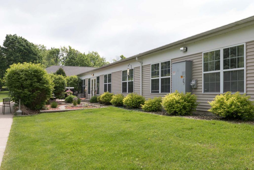 A single-story house with a well-maintained lawn and garden area.