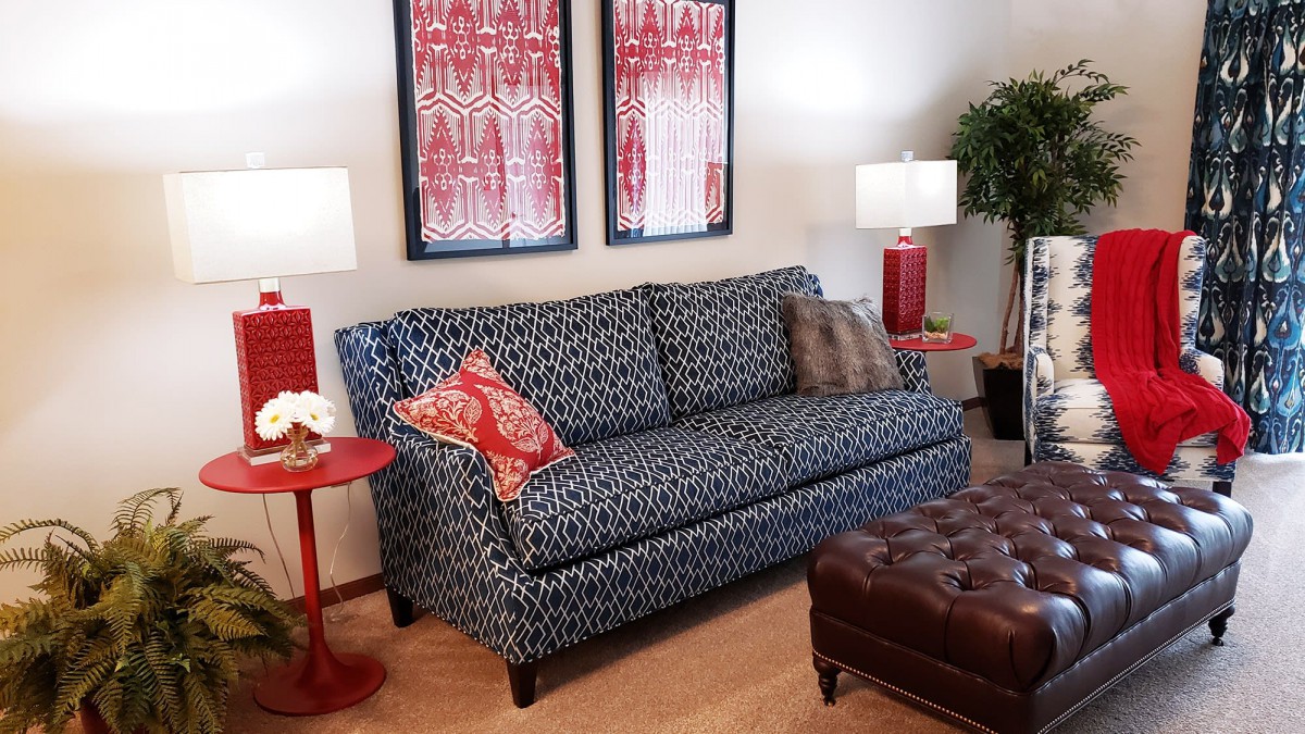 A well-furnished living room featuring a patterned sofa, two matching lamps, and vibrant artwork on the wall.