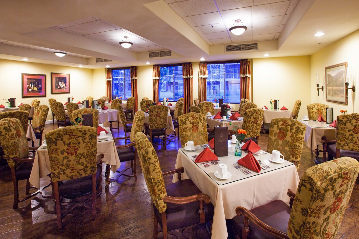 An elegant restaurant dining room with neatly arranged tables and chairs.