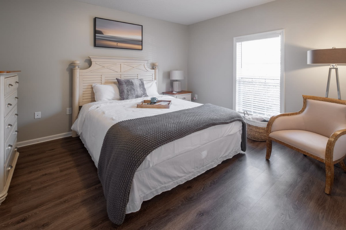 A modern bedroom with a cozy bed, stylish decor, and natural light.