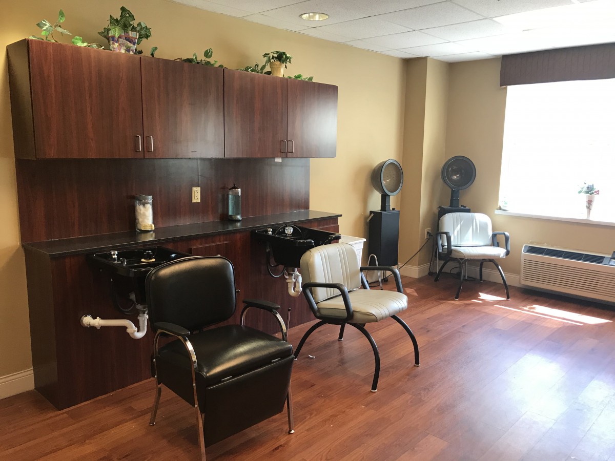 A cozy salon interior with hair styling chairs and dryers.