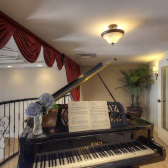 A grand piano with sheet music in a well-decorated room.