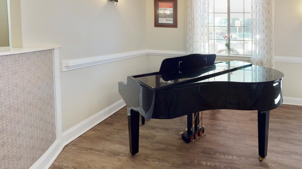 A grand piano in a bright, elegantly decorated music room.
