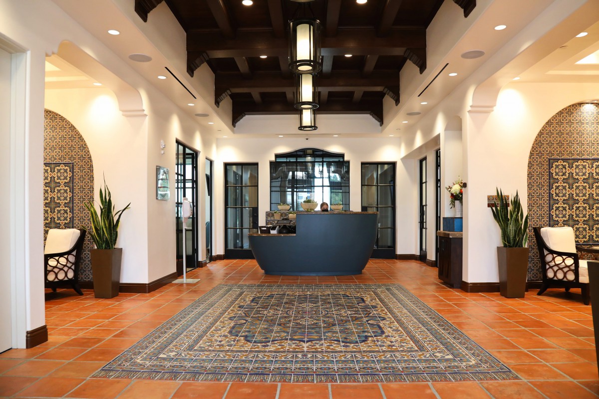 A modern office lobby with a central reception desk and decorative elements.