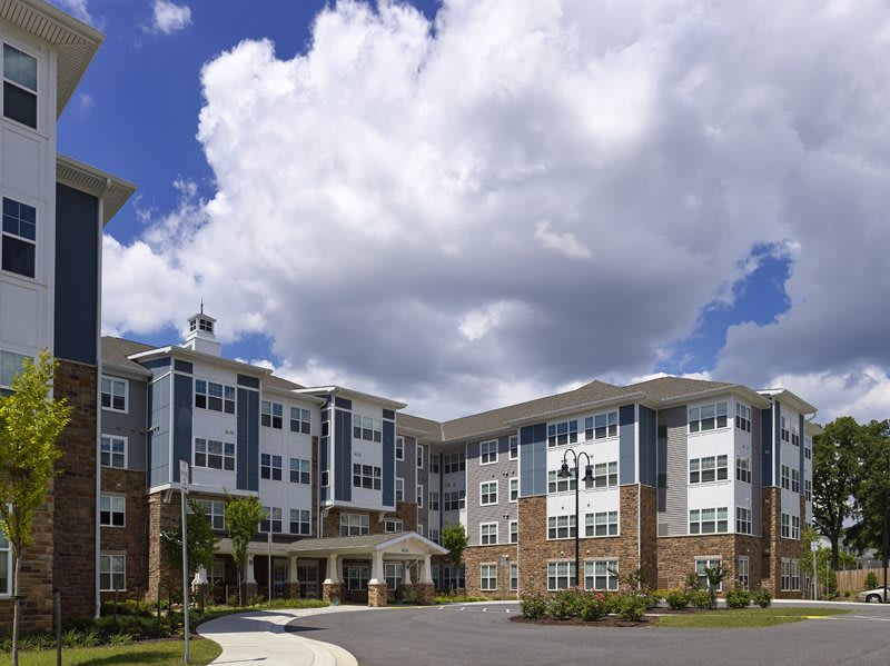 A modern residential apartment building under a partly cloudy sky.