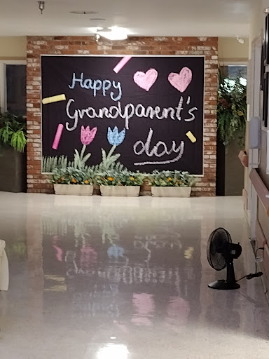 A vibrant chalkboard greeting celebrating Grandparents Day, adorned with colorful drawings and a touch of greenery.