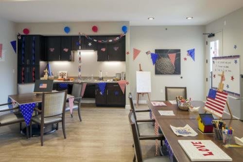 A decorated kitchen and dining area prepared for a party, featuring colorful balloons and banners.