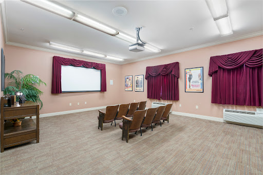 A cozy movie theater-style presentation room, equipped with comfortable seating and a projector for screenings.