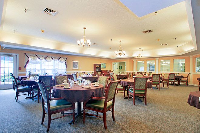 A spacious and well-lit dining room with neatly arranged tables and chairs.