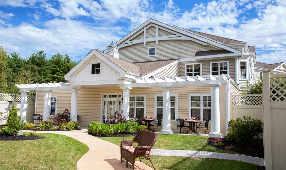 A charming residential house with a large patio and garden area under a clear blue sky.