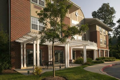 A residential building with a landscaped exterior and trees.
