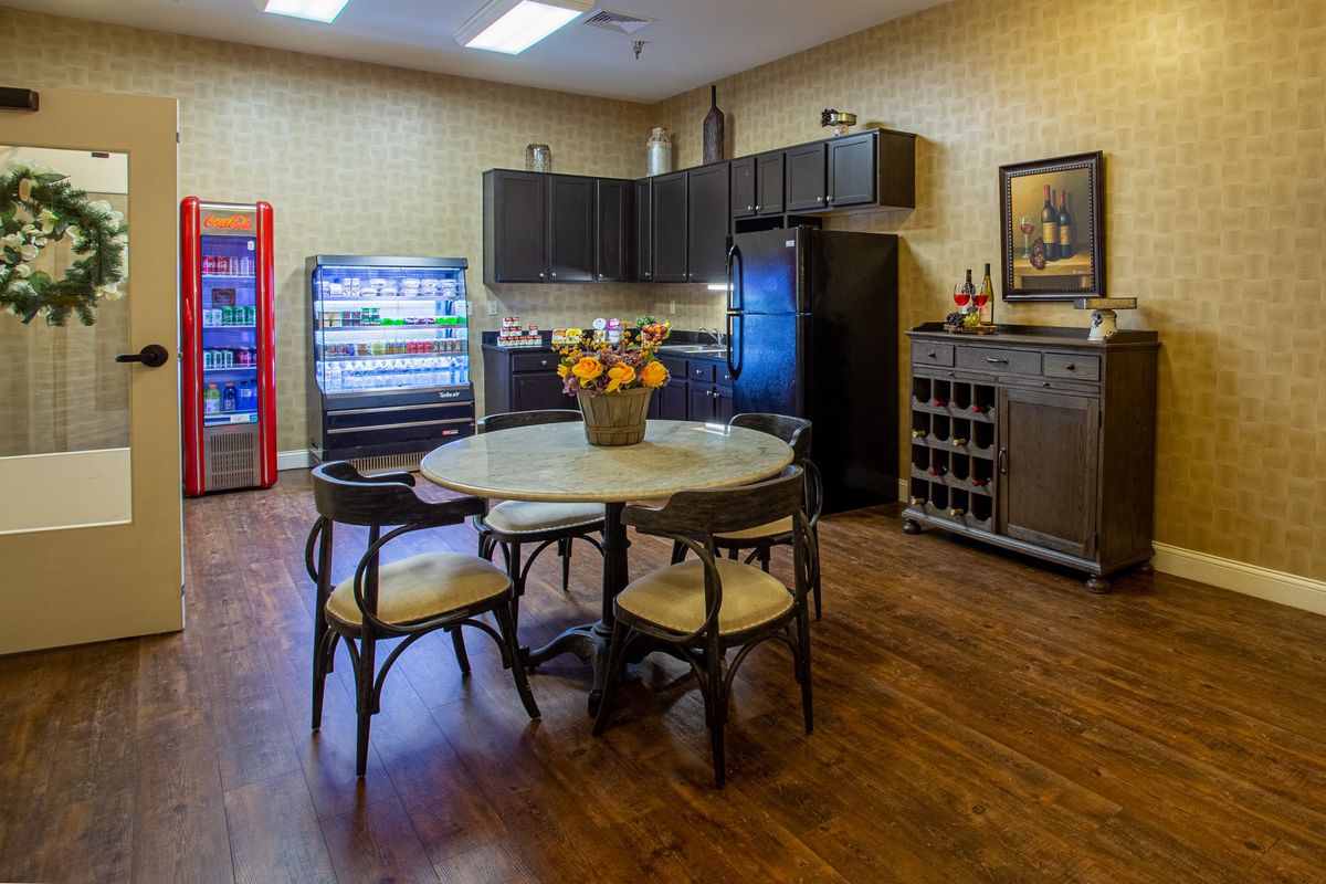 A cozy kitchen area with a round table, chairs, and modern appliances.