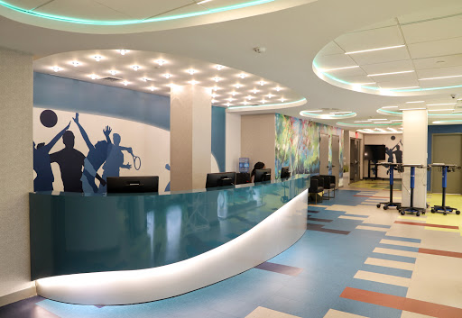 A bright and modern office reception area featuring a sleek design and colorful flooring.