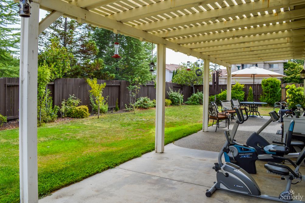 A well-maintained backyard with a patio, pergola, and garden.