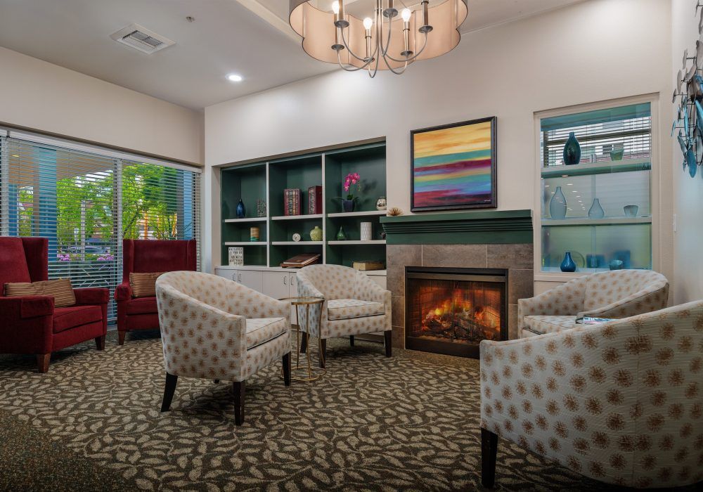 A cozy living room with patterned chairs and a warm fireplace.