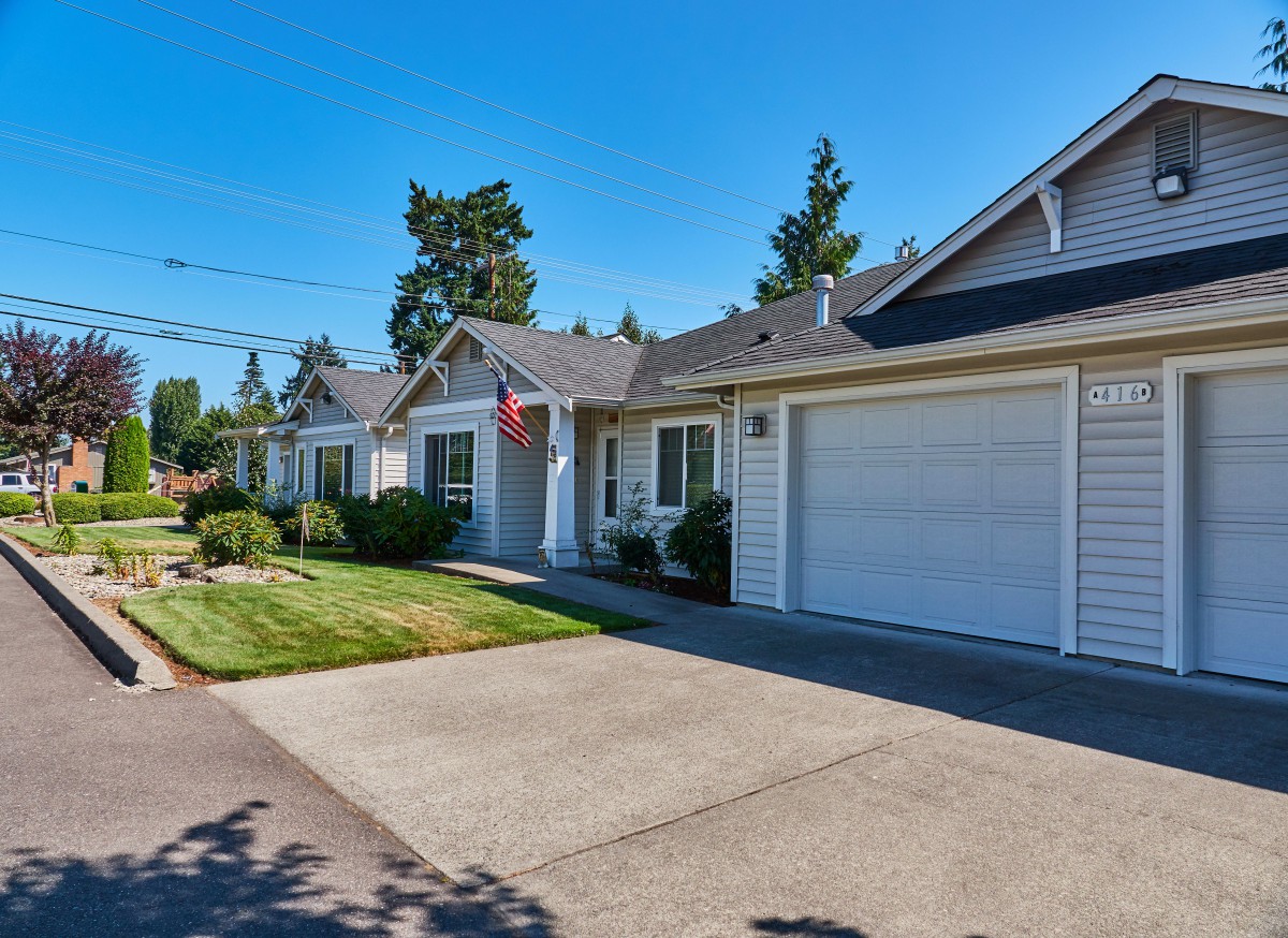 Suburban house with a driveway and garage on a sunny day.