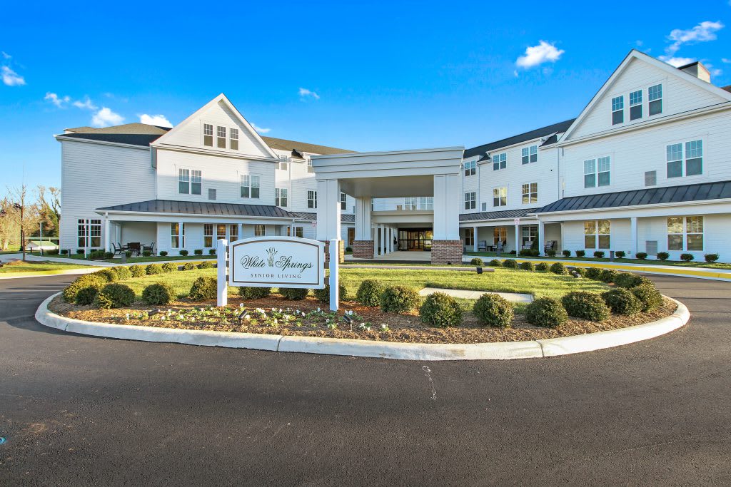A modern, multi-story building with well-maintained landscaping and a prominent entrance sign.