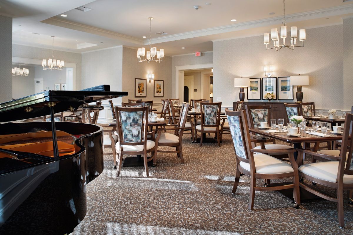 Elegant dining area with a piano and stylish furnishings.
