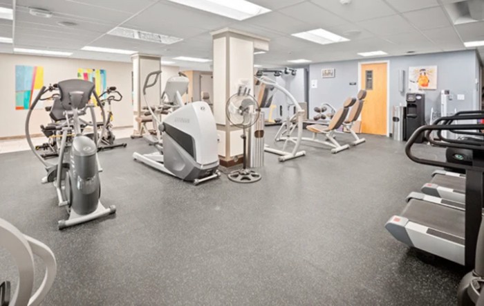 A spacious gym with a variety of fitness equipment and exercise machines.