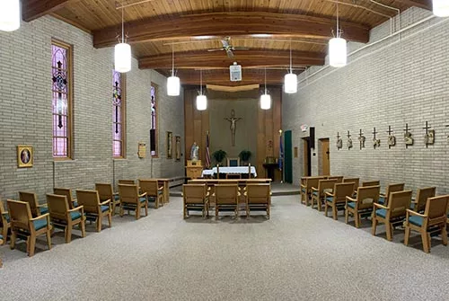 Interior view of a chapel with seating and an altar.