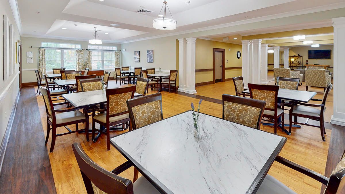 A spacious and elegantly designed dining room with multiple tables and chairs, well-lit by overhead lights.