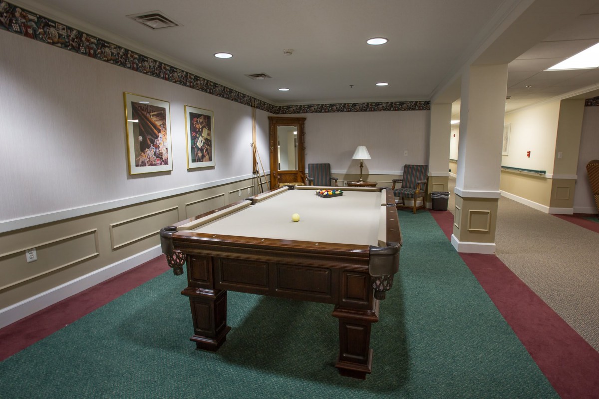 A billiards room featuring a pool table and wall decorations.
