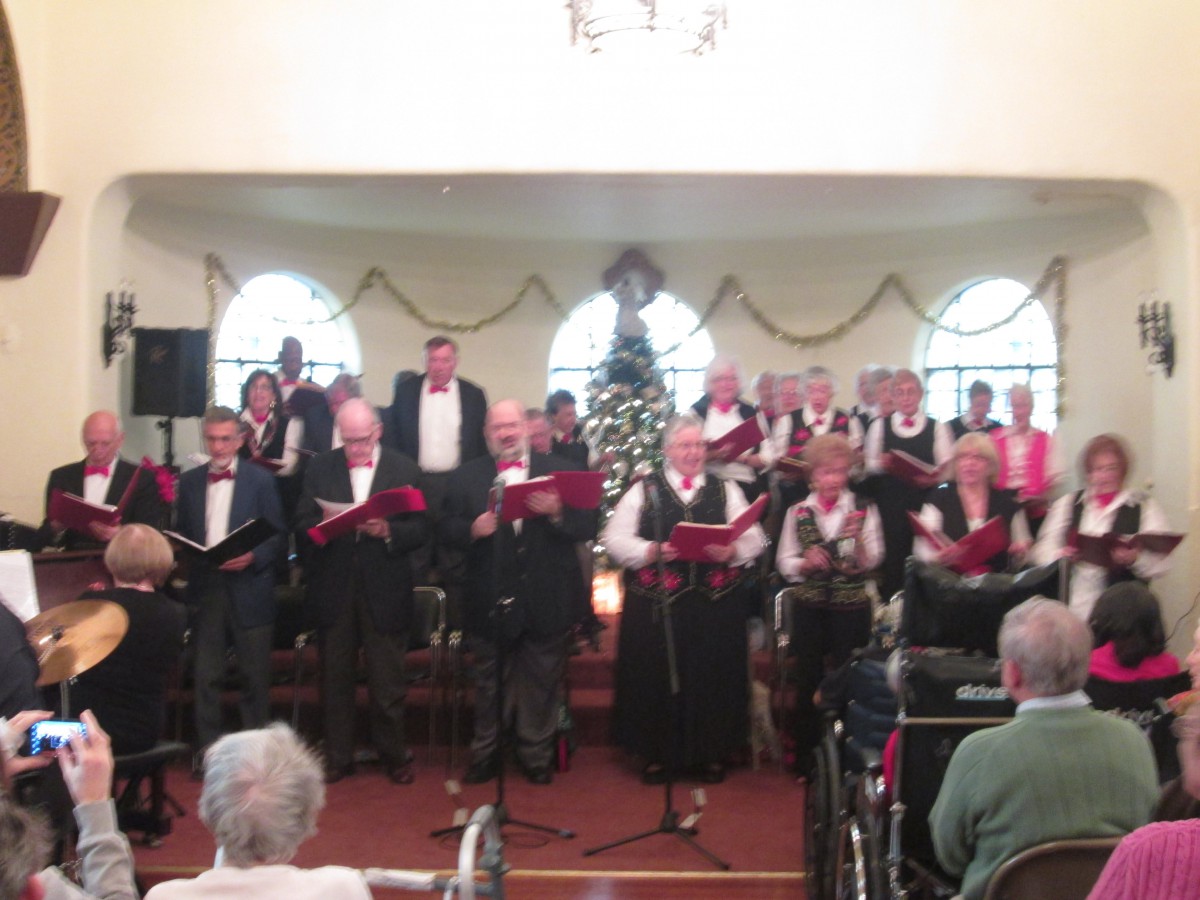 A choir performing in front of an audience in an indoor setting.
