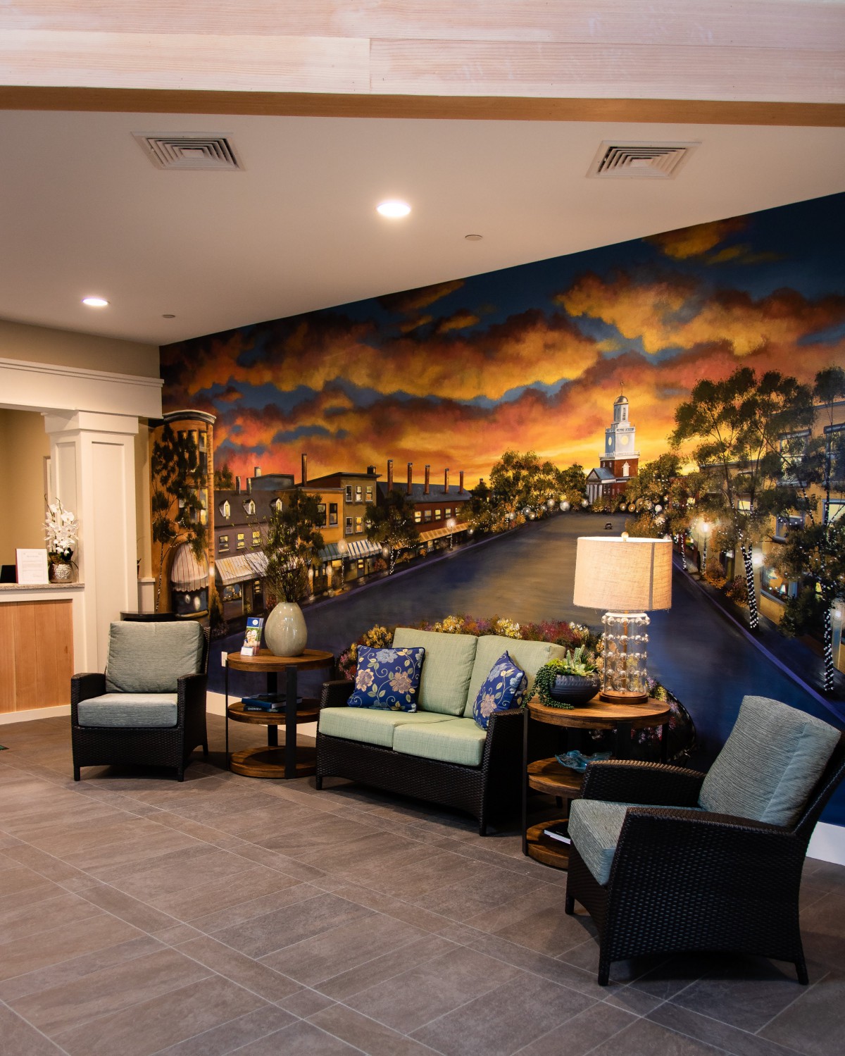 A cozy waiting room with comfortable seating and a vibrant mural on the wall.