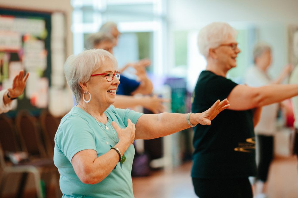 A group of elderly individuals participating in a fitness class indoors.