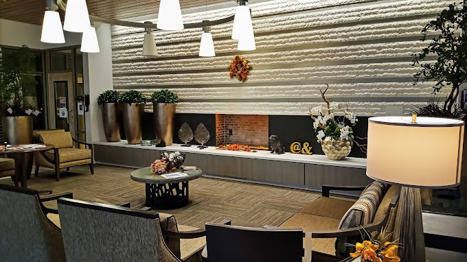 A modern living room with elegant decor, featuring a fireplace and contemporary lighting.