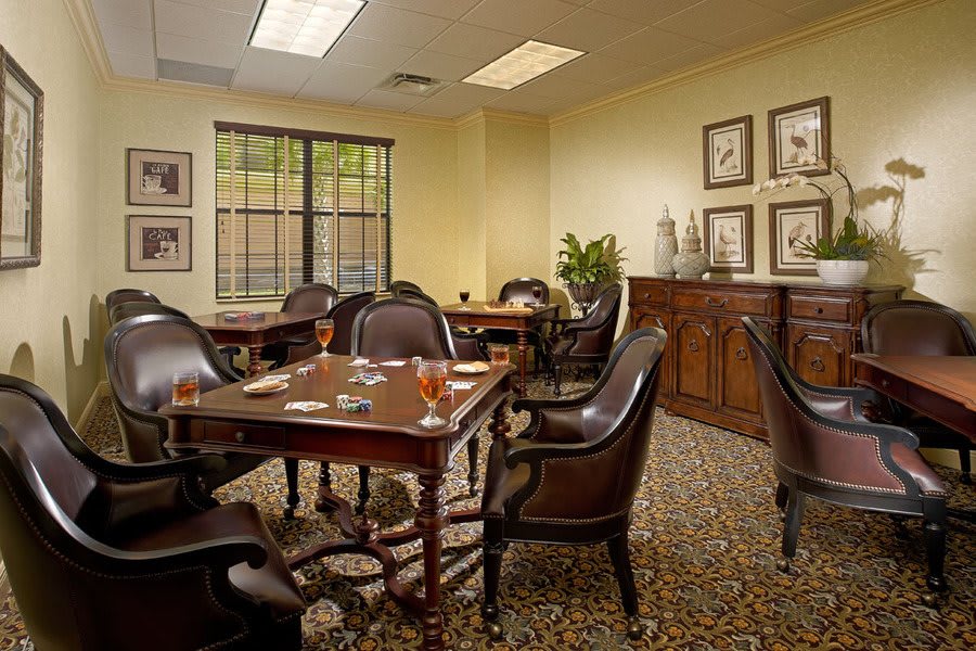 A well-furnished conference room with wooden tables and leather chairs, set up for a formal meeting.