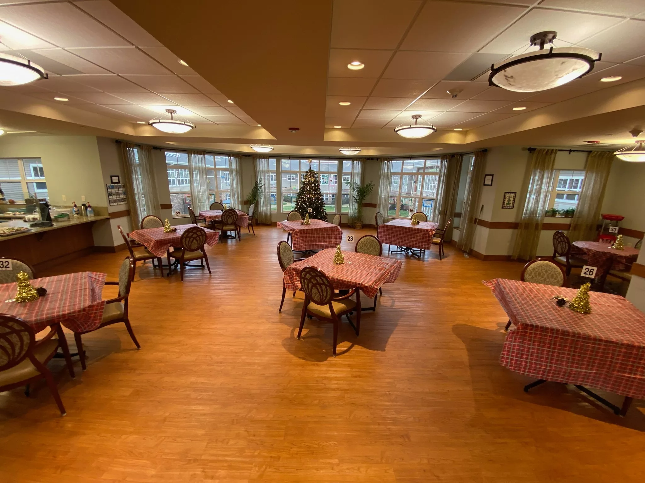 A cozy dining area with wooden floors and neatly arranged tables.