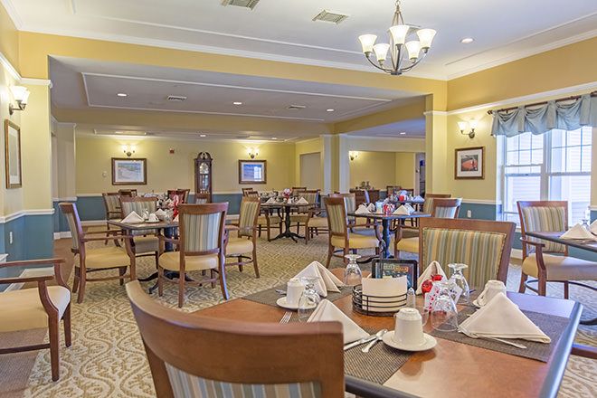 A spacious dining room with elegantly set tables and comfortable seating.