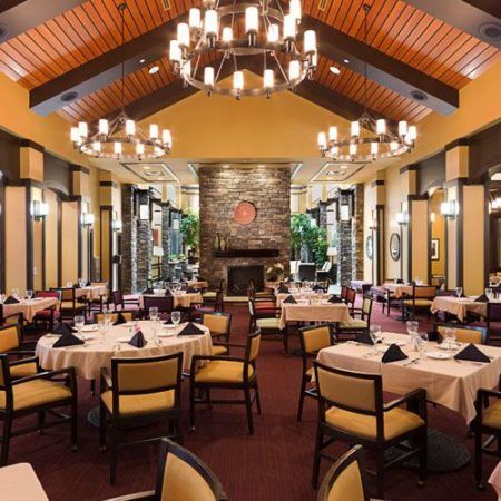 Elegant restaurant interior with chandeliers and neatly arranged tables.