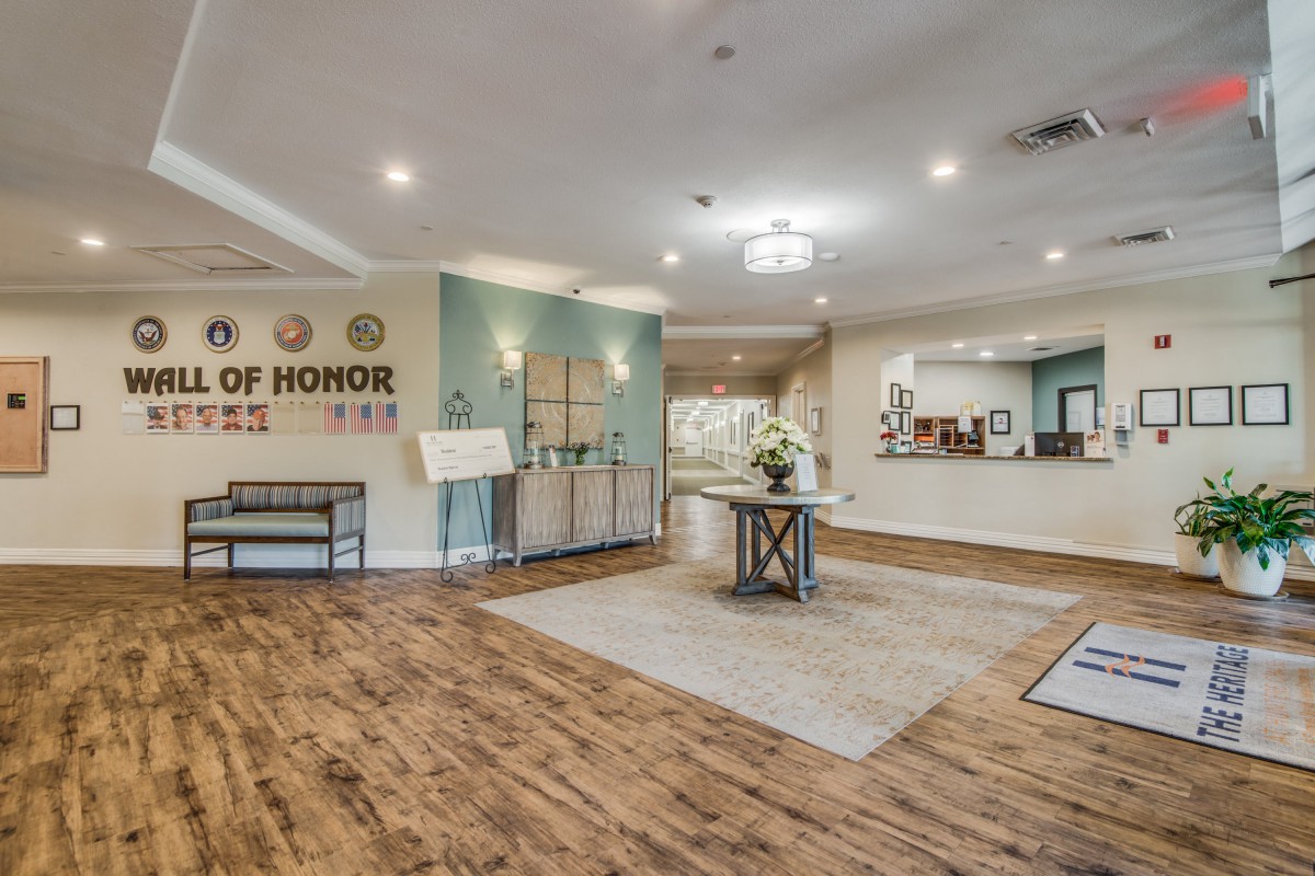A welcoming lobby with wood flooring and modern decor, featuring a reception desk and seating area.