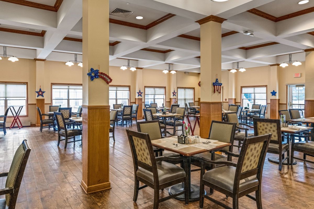 An empty dining room with neatly arranged tables and chairs, featuring decorative elements.