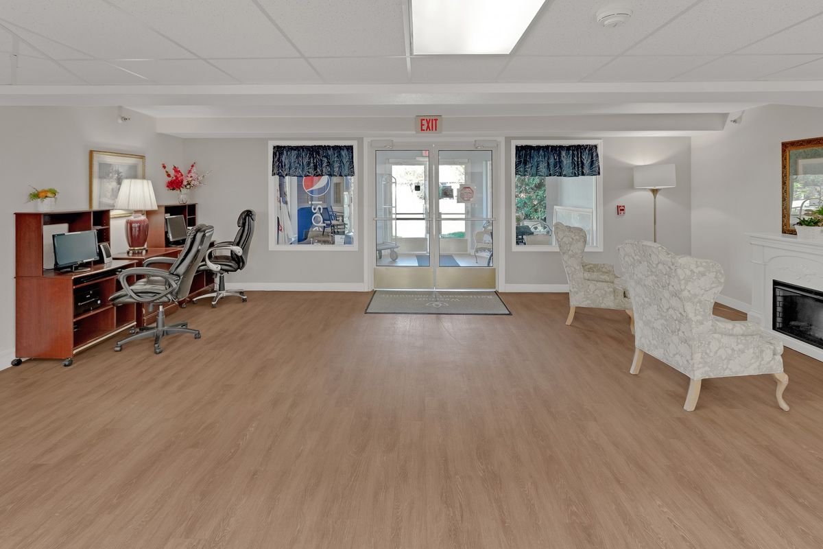 A bright and welcoming office lobby with seating and a computer desk.