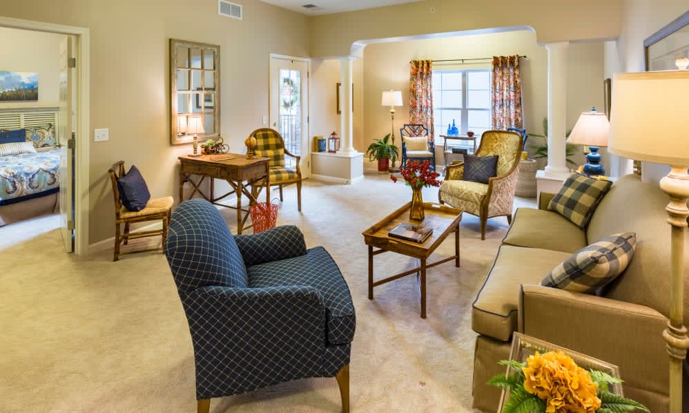 A cozy, traditionally decorated living room with comfortable seating and warm lighting.
