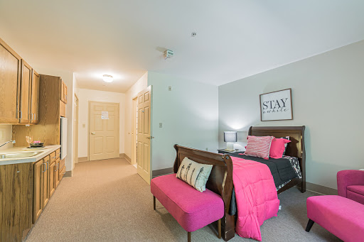 A stylish and modern bedroom featuring a cozy bed, vibrant pink accents, and warm lighting.